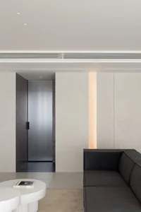 A modern minimalist living space featuring minimalist furniture and a concrete floor.