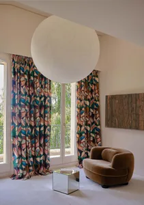 Modern living room with colorful patterned curtains and a cozy brown sofa.