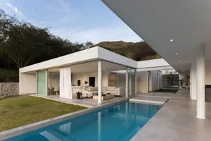 A contemporary residential exterior with large glass windows and a swimming pool.