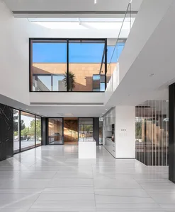 Modern residential interior featuring marble floor, large windows, and minimalist design.