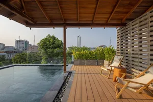 Modern residential space featuring a wooden deck with a pool, plants, and comfortable seating.