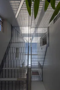 Modern staircase featuring a metal grid ceiling design, providing unique lighting and structural aesthetic.