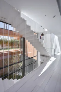 White staircase with glass panels in a modern architectural interior design.