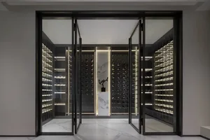 An industrial-style wine cellar with illuminated glass shelves and a central display area.