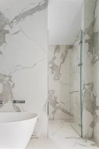 Modern minimalist bathroom featuring marble walls and floor.