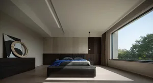 A minimalist bedroom with a large bed, wooden headboard, and floor-to-ceiling windows.