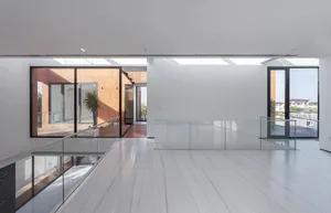 Modern minimalist living room featuring glass walls and a white floor.
