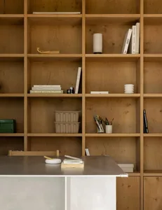 Minimalist office space with wooden shelves and a metal table.
