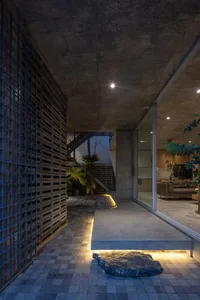A minimalist residential interior featuring concrete and glass materials.