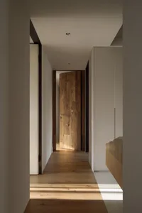A wooden corridor with a minimalist design, featuring clean lines and warm, natural wood flooring.