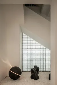 A modern interior design installation featuring abstract metal sculptures illuminated with light.
