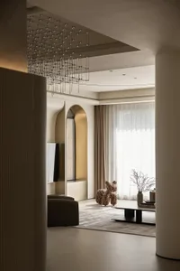 A modern living room with neutral-tones decor, featuring a minimalist design with an arched doorway and a chandelier with a g
