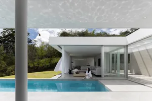 A modern minimalist house featuring concrete and glass materials.