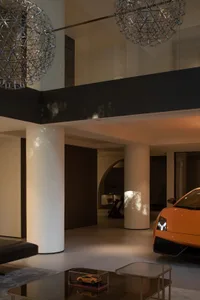 A luxurious residential garage featuring modern design elements such as concrete columns and metal ceilings, with a prominent