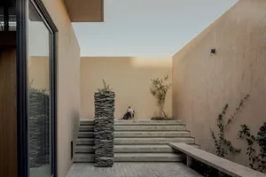 A modern interior design featuring stone stairs with a dog sitting on the steps.