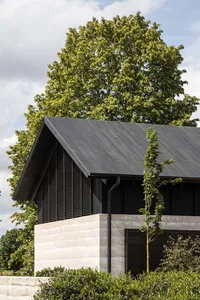 Modern house exterior with black shutters and concrete material