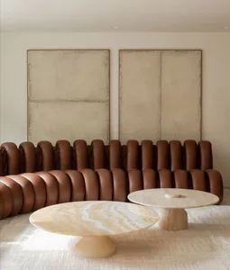 A modern living room featuring a unique sofa with circular cushions and marble tables.