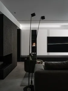 A modern living room featuring textured concrete walls and floors, with minimalist furniture and contemporary art.