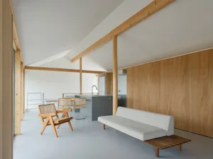 Modern minimalist living room with white walls, wood furniture, and open floor plan.