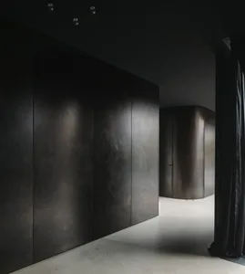 Modern minimalist interior with metallic walls and floor, featuring clean lines and geometric shapes.