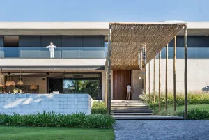 Modern residential exterior with concrete structure and large glass windows.