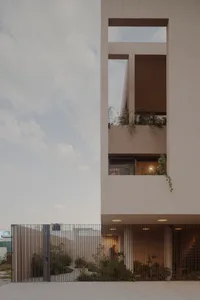 A modern residential living room with concrete walls and a large glass window.