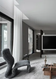 A modern living room with concrete walls and a minimalist design.