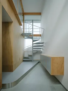 A minimalist interior with a metal staircase and wooden walls.