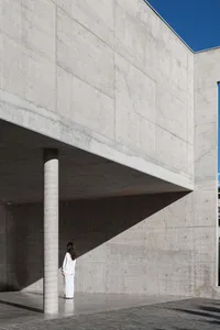 A modern architecture building made of concrete with a person standing in front.