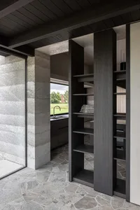Concrete porch with black columns and a stone floor