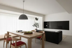 Modern living and dining area with wooden furniture and black fabric accents.