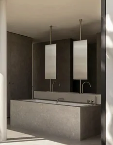 Dark minimalist bathroom featuring a concrete bathtub, double mirrors, and metal accents.