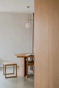 Modern minimalist dining room featuring a wooden table and chairs.
