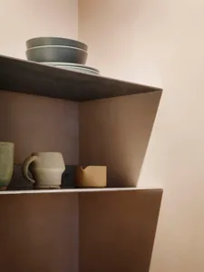 Concrete shelf with ceramic mugs and bowls.