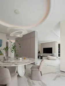 Modern minimalist living room with marble finishes, featuring a sleek, round dining table and contemporary seating.