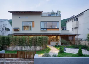 A modern residential exterior featuring concrete and glass materials.