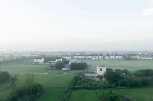 A aerial view of a urban landscape with buildings and green fields.