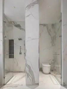 A modern bathroom featuring marble walls and floor, with a shower and toilet.