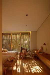 A modern bedroom featuring hardwood flooring and furniture with a minimalist design.
