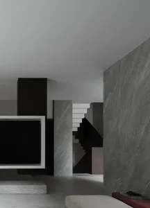 Modern interior design featuring a floating staircase with dark metallic elements in a living room setting.