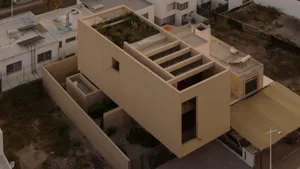 A modern home extension with a rooftop garden, featuring concrete and glass materials.