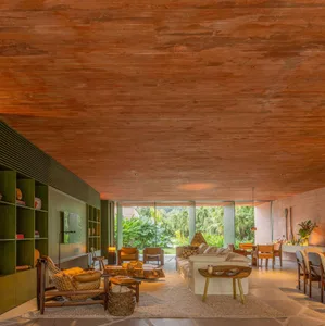 A modern living room with a wooden ceiling and a large window overlooking a lush garden.