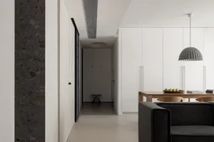 A modern living room with concrete flooring and minimalist furniture.