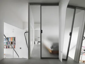 Modern minimalist bedroom with frosted glass doors and white interior design.