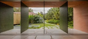 Modern residential interior with concrete floor and open view of lush green garden.