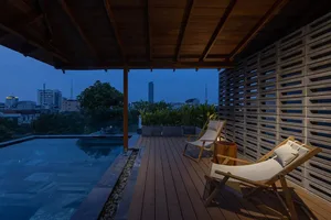 Modern residential patio featuring glass walls and a wooden deck.