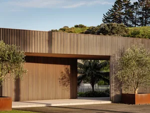 A modern entryway featuring a wooden wall with vertical panels and an overhang.
