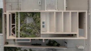 A modern interior design featuring a concrete space with plants and a window.
