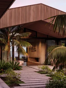A modern outdoor space featuring wooden structures and palm trees.