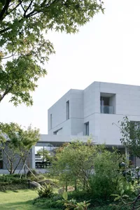 An exterior view of a modern residential house featuring glass and concrete materials.